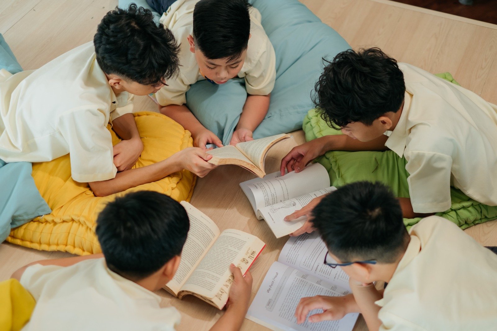 Primary students reading together on floor cushions in the library