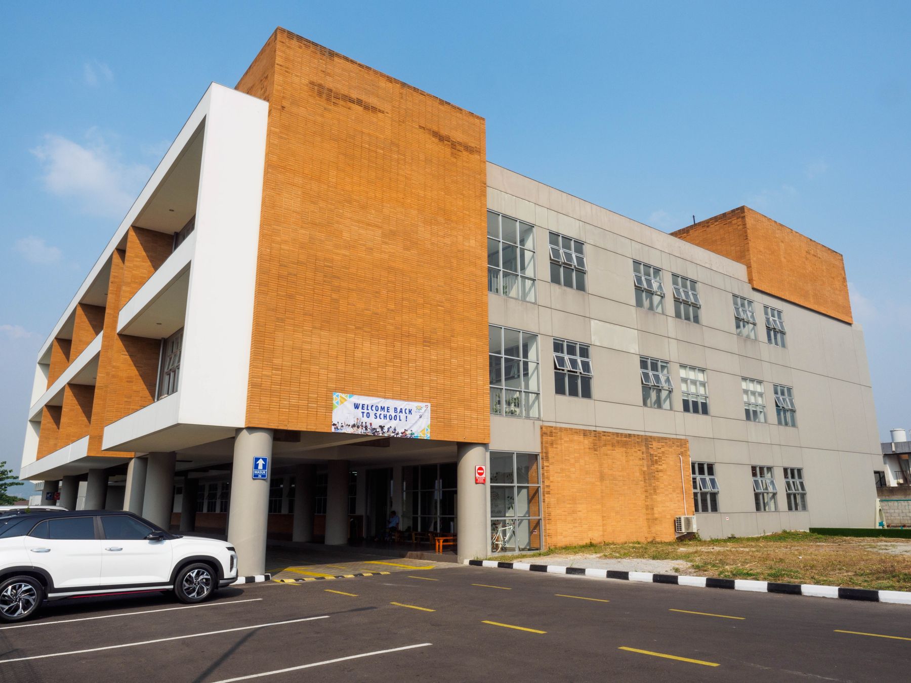 The main entrance of the Kota Baru Parahyangan campus, with its orange brick front