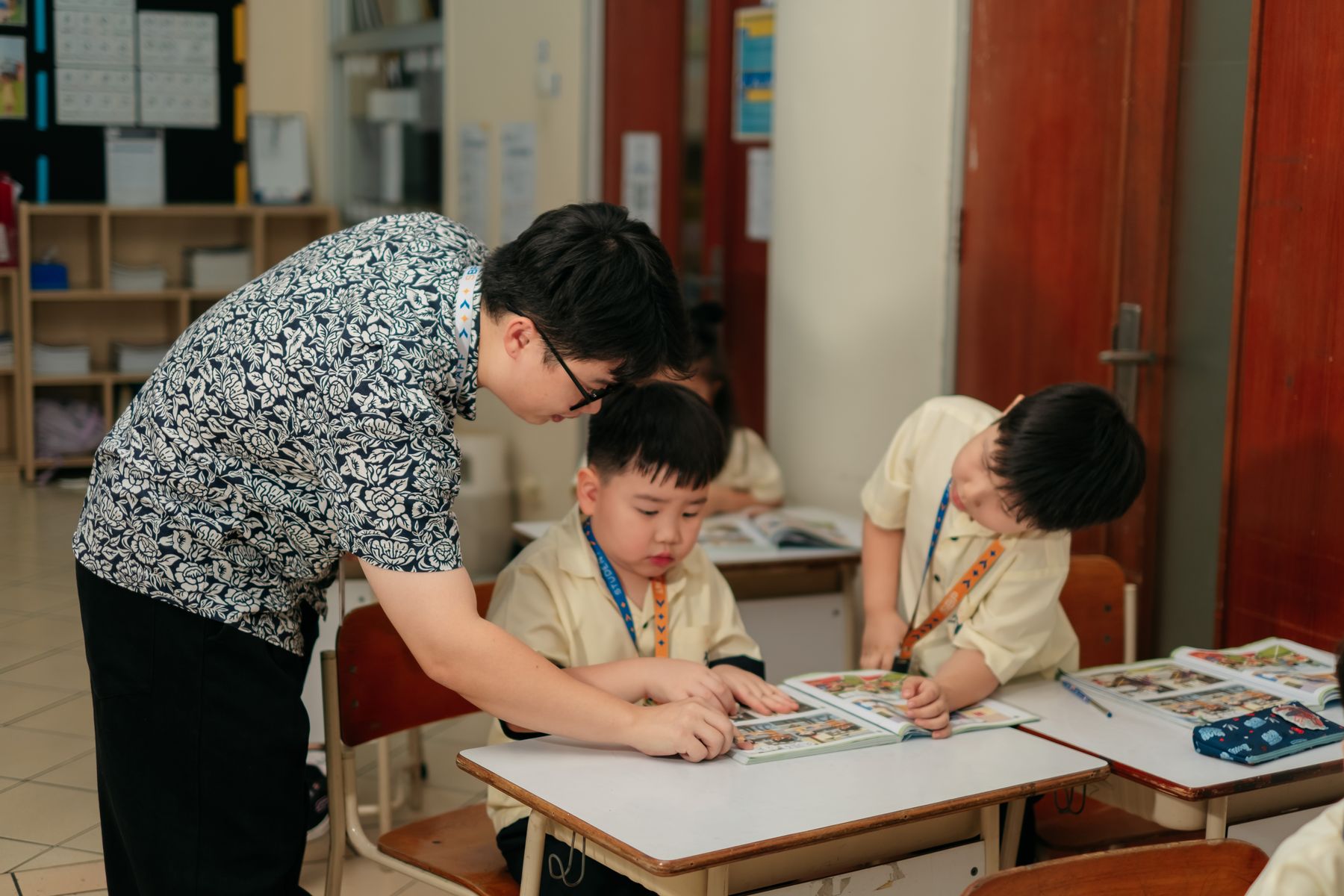 A teacher working with two young students